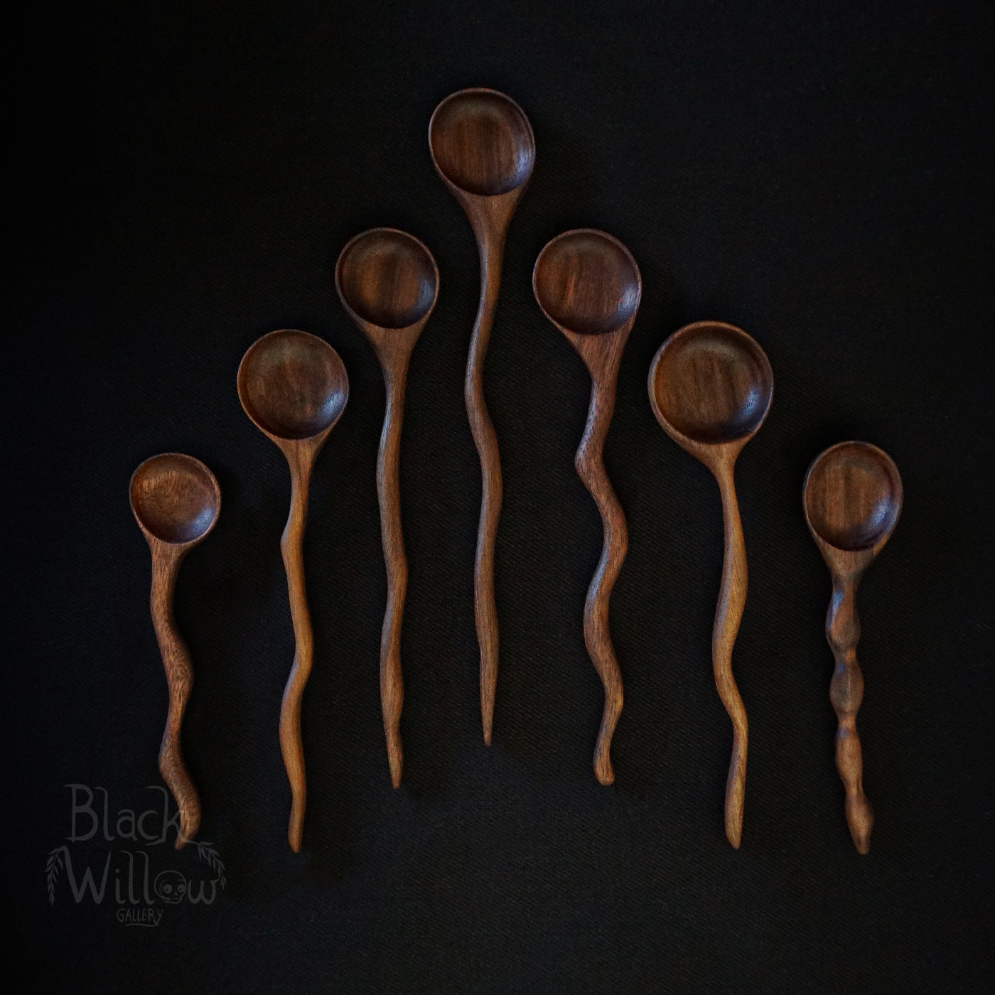 Seven wooden spoons, on a black background