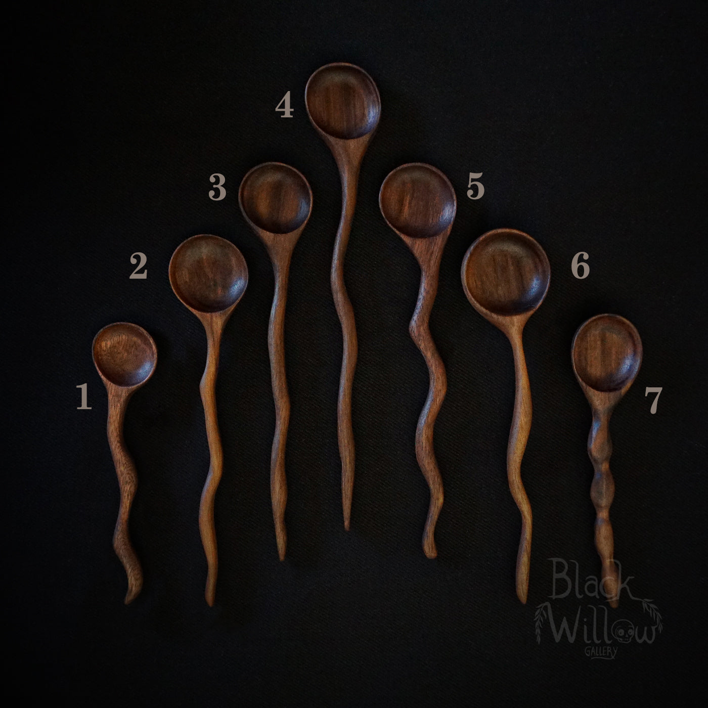 Seven different wooden spoons and displayed on a black background, numbered 1 through 7. The spoons have a warm medium-brown wood finish with visible grain patterns.