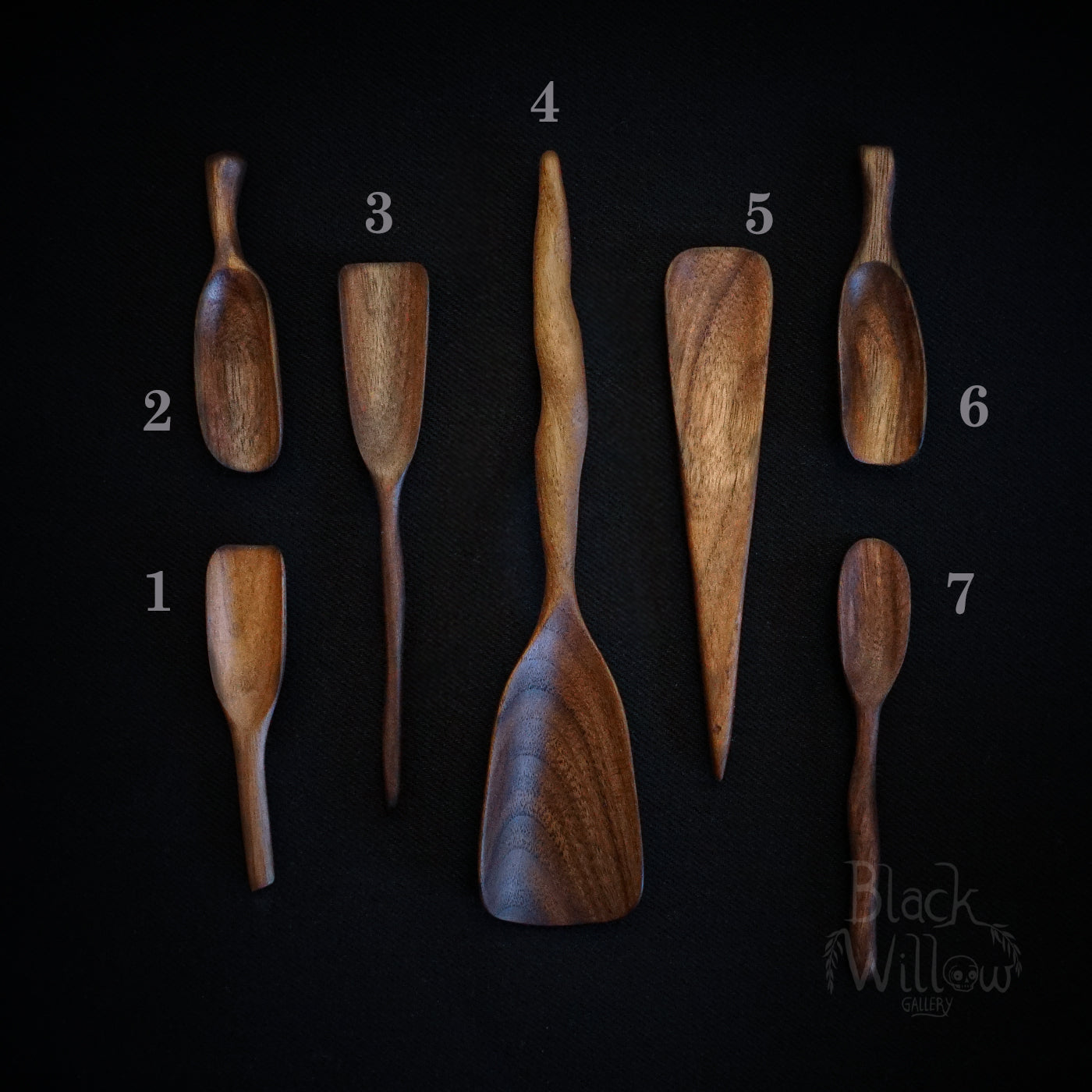 Seven different wooden spoons and spatulas displayed on a black background, numbered 1 through 7. The spoons have a warm medium-brown wood finish with visible grain patterns.